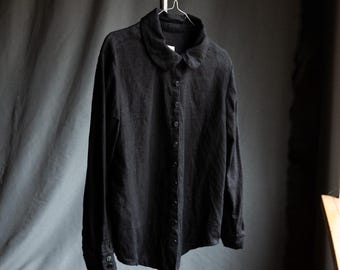 May include: A black long-sleeved collared shirt with a button-up front.