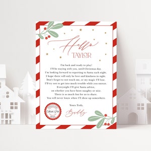 Può includere: Una lettera a tema natalizio con un bordo a righe rosse e bianche. È indirizzata a "Taylor" e include un messaggio da "Buddy" con un sigillo del "Polo Nord". Il design presenta rametti verdi e stelle dorate.