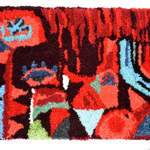 Puede incluir: Una alfombra abstracta colorida con un dise&ntilde;o texturizado tejido a mano. La alfombra presenta tonos de rojo, azul, verde y negro.
