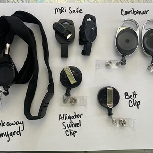 May include: Assortment of black badge holders and lanyards. Includes a breakaway lanyard, MRI safe clips, carabiner style holders, alligator swivel clips, and belt clip style holders. Text labels identify each type.