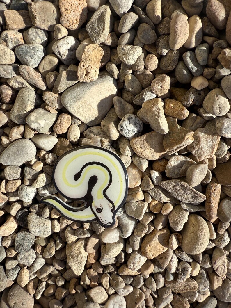 May include: A set of three ceramic mugs with a speckled, matte finish. The mugs are in shades of cream, light gray, and dark gray. Each mug has a simple, modern design and a rounded handle.