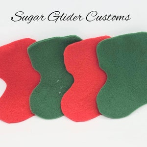 May include: Four felt fabric pieces in the shape of a stocking. Two are red and two are green.