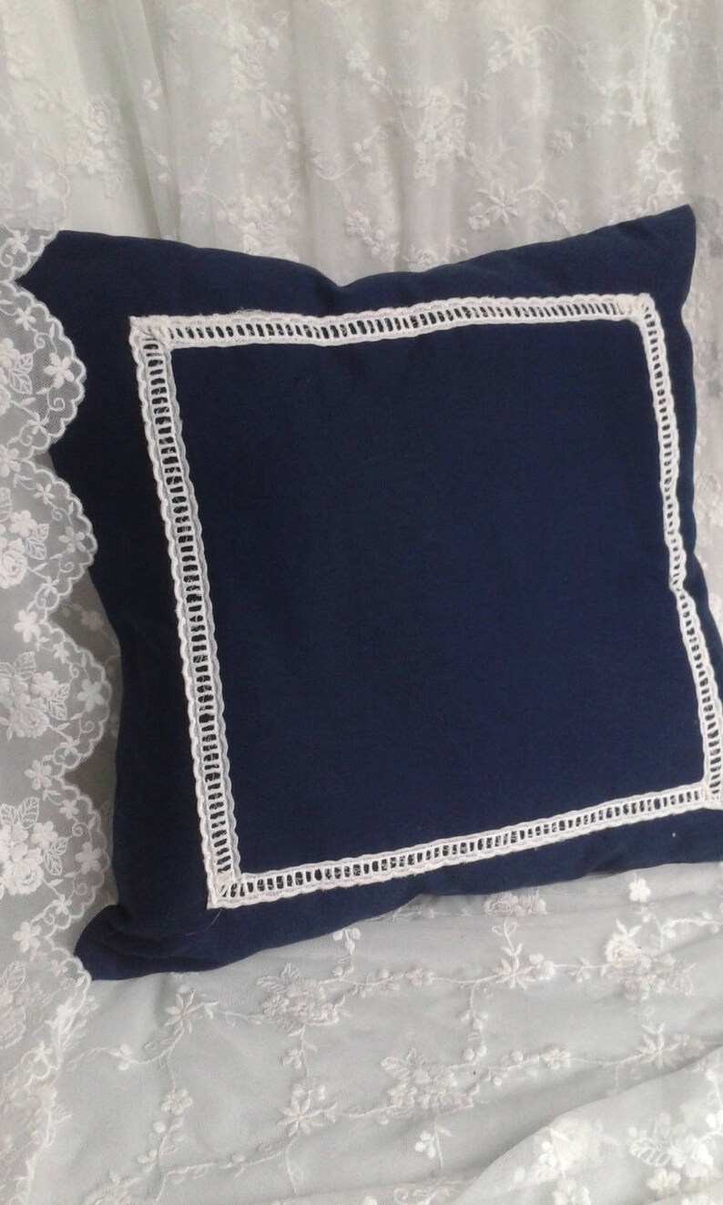blue cushion with white embroidered days