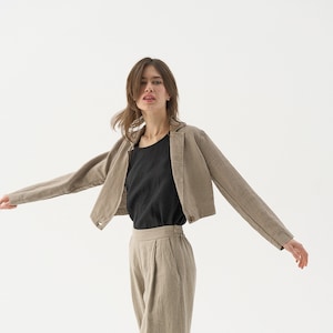 Cropped linen jacket with classic jacket lapels. Ends around navel. One large button at the bottom hem.