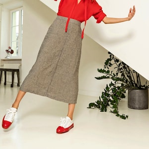 mid-calf length trapeze silhouette linen skirt. Stylised seam over the entire length of the skirt in the mid-front.