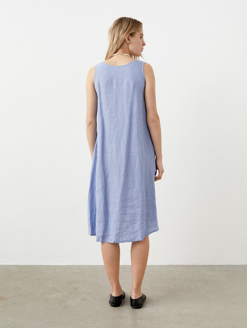 Puede incluir: Un vestido sin mangas de color azul b&iacute;garo que llega hasta la rodilla, con cuello redondo y un corte holgado y relajado. La prenda est&aacute; confeccionada en un tejido texturizado y presenta un dise&ntilde;o sencillo y sin adornos.