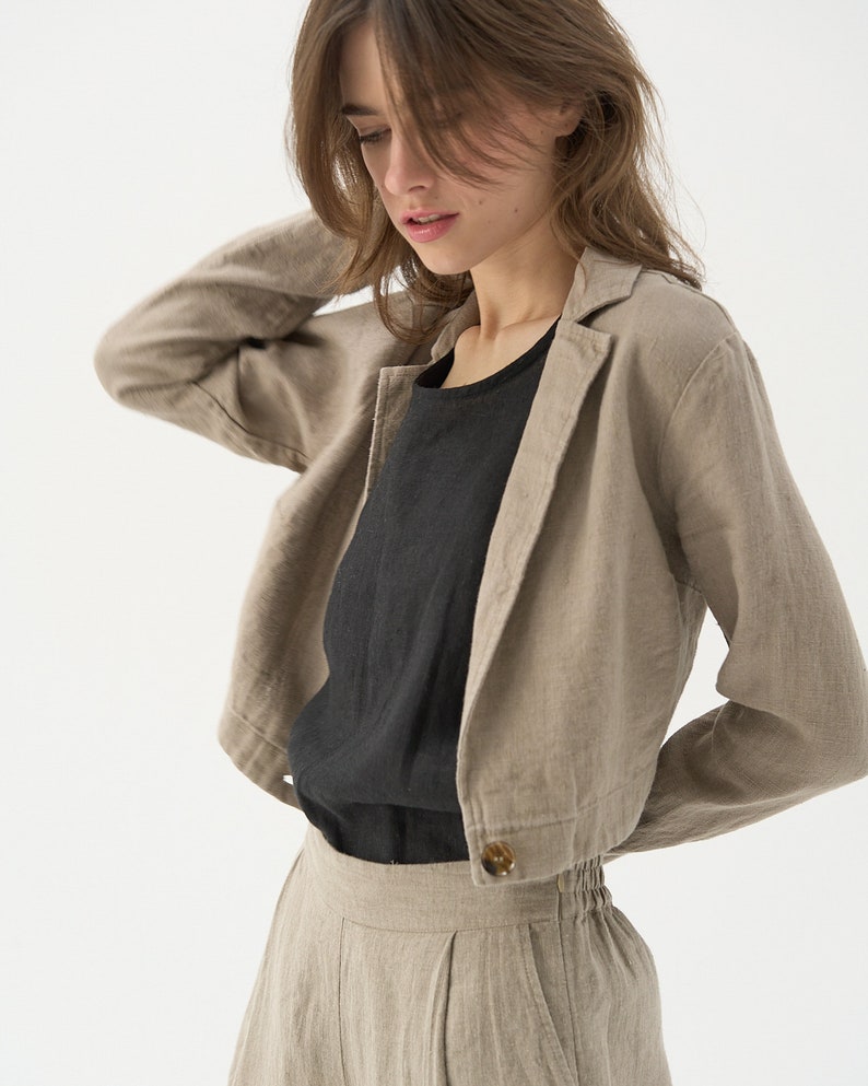 Cropped linen jacket with classic jacket lapels. Ends around navel. One large button at the bottom hem.