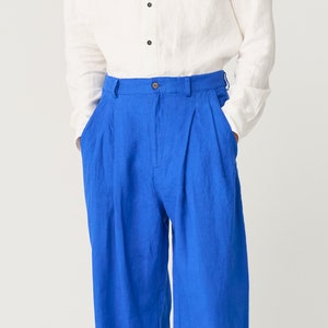 May include: A pair of blue linen pants with pleats and a button fly.