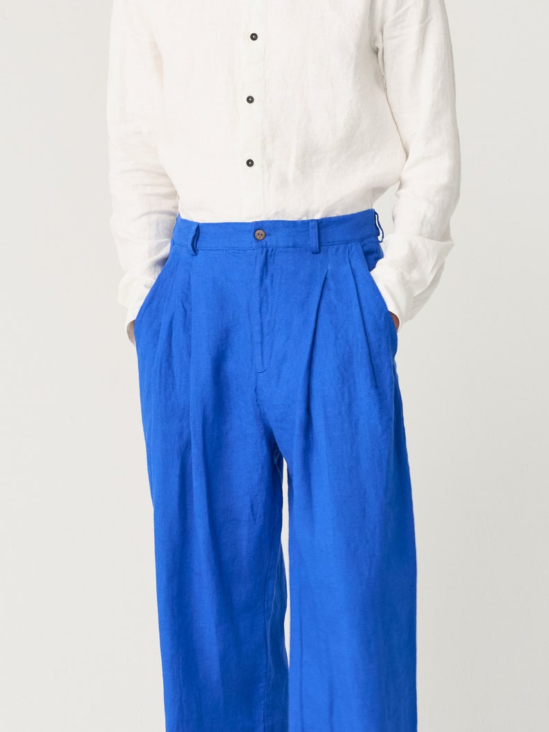 May include: A pair of blue linen pants with pleats and a button fly.