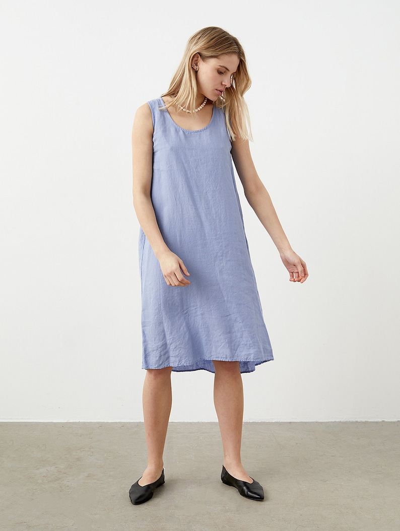 Puede incluir: Un vestido sin mangas hasta la rodilla en un color azul b&iacute;garo s&oacute;lido. La prenda presenta un escote redondo y una silueta recta y relajada. La tela tiene un tejido texturizado visible y el dobladillo cae justo por encima de las rodillas.