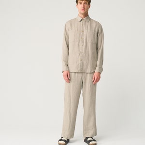 May include: A light brown linen shirt and matching pants. The shirt has a button-down collar and long sleeves. The pants have a straight leg.