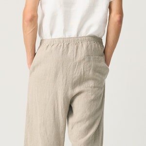 May include: Beige linen pants with a drawstring waist and a single back pocket.