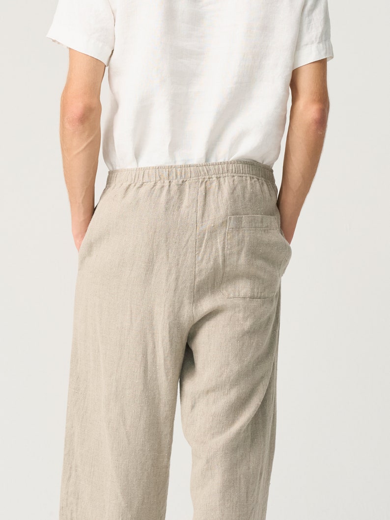 May include: Beige linen pants with a drawstring waist and a single back pocket.