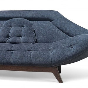 May include: A blue, tufted, mid-century modern sofa with a curved, wave-like design and wooden legs.