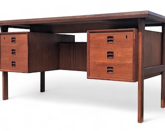 May include: A mid-century modern teak desk with a rectangular top and four drawers. The desk has a light brown finish and is made of solid wood.