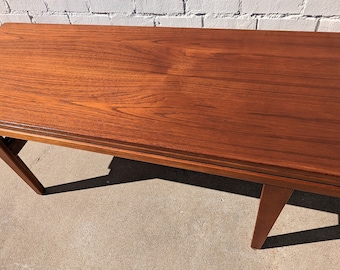 May include: A dark brown wooden folding table with a rectangular top and tapered legs. The table is made of solid wood and has a natural finish.