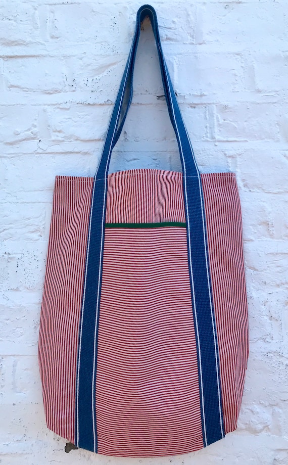 Tote bag. Red vertical striped denim bag with a deep front horizontal striped denim pocket. 100% cotton.