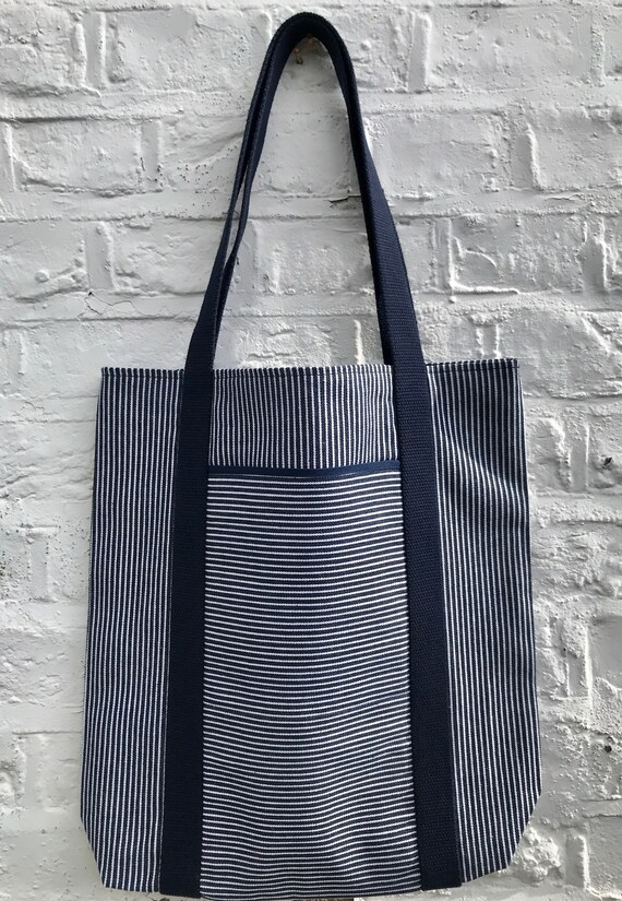 Tote bag. Navy blue vertical striped denim bag with a deep front horizontal striped denim pocket. 100% cotton.