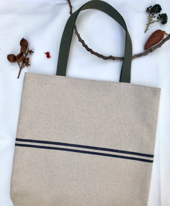 Tote bag. Heavyweight natural woven canvas with two horizontal blue stripes. Lined with a beautiful striped cotton shirting fabric.