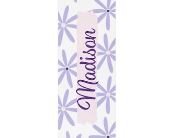May include: A white yoga mat with a purple floral pattern and the name "Madison" written in purple on a pink background.