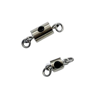 May include: Two silver metal clasps with black accents and small loops on each end. The clasps are designed to connect two pieces of jewelry together.