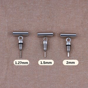 May include: Three silver metal tubes with a small screw-on cap and a loop at the top. The tubes are labeled 1.27mm, 1.5mm, and 2mm.