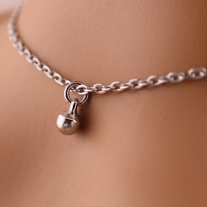May include: A silver chain necklace with a small, round, silver pendant.