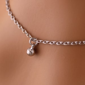 May include: A silver chain necklace with a small, round pendant.