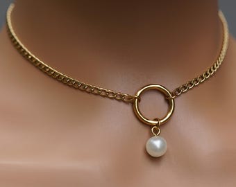 May include: A gold chain choker necklace with a round pendant and a single white pearl hanging from it.