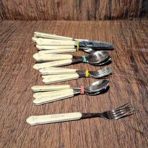 May include: A set of silverware with floral patterned handles. The set includes a knife, fork, and spoon.