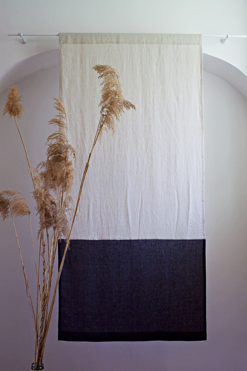 Puede incluir: Un tapiz de pared de lino de dos tonos. La secci&oacute;n superior es de color beige claro, la del medio es blanca y la inferior es gris oscuro. En primer plano, hierbas ornamentales secas, que a&ntilde;aden un elemento natural a la decoraci&oacute;n.