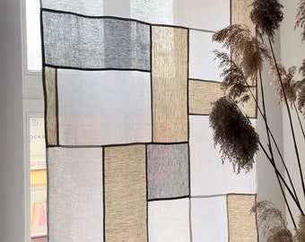 May include: A rectangular window curtain featuring a patchwork design of semi-sheer fabric panels in shades of white, light gray, and beige. The panels are joined by thin dark brown borders, creating a geometric grid pattern hanging from a black rod.