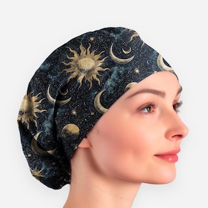May include: A dark blue surgical scrub cap featuring a celestial design. The cap is patterned with gold suns, crescent moons, stars, and planets. The background has a dark blue and teal watercolor effect.