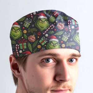 May include: A green and red Christmas themed scrub hat with a repeating pattern of the Grinch, candy canes, presents, and ornaments.