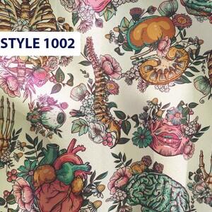 May include: A white fabric with a colorful anatomical pattern. The pattern includes a heart, brain, lungs, spine, and skeleton. The fabric is decorated with flowers and leaves. The text "STYLE 1002" is printed on the fabric.
