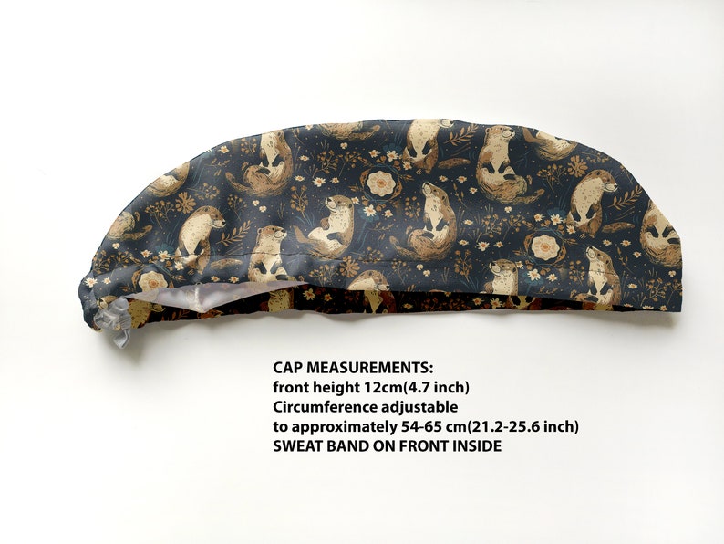 May include: A navy blue cap with a repeating pattern of otters, flowers, and foliage in shades of brown and cream. The cap's front height is 4.7 inches, and the circumference is adjustable from 21.2 to 25.6 inches. It has a sweatband on the front inside.