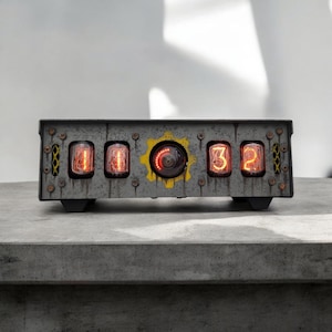 May include: A vintage-style clock with a distressed metal casing and four red glowing Nixie tubes displaying the time 11:32. The clock has a yellow gear with a red glowing center.