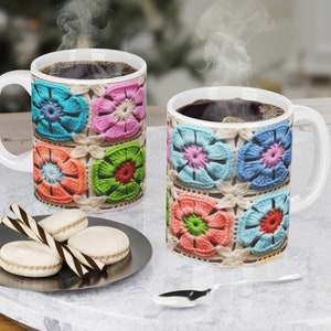 Puede incluir: Dos tazas de cer&aacute;mica blanca con un patr&oacute;n de flores de ganchillo de colores. Las tazas est&aacute;n llenas de caf&eacute; y sale vapor de ambas tazas.