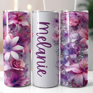 May include: Three stainless steel tumblers with a floral design. The tumbler in the middle is white with the name "Melanie" printed in purple. The tumblers on either side feature a pink, purple, and white floral design with pearl accents.