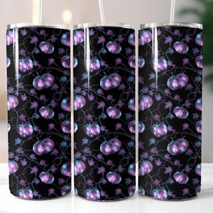 May include: Three stainless steel tumblers with a black background, featuring a repeating pattern of purple pumpkins, vines, and leaves. The pumpkins have a gradient effect, and the leaves are a mix of purple and blue.