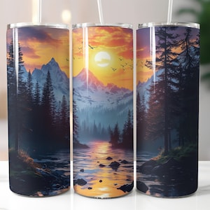 May include: Three stainless steel tumblers featuring a mountain sunset design. The tumblers depict a silhouette of mountains, trees, and a lake with a sunset in the background. These tumblers are a great way to enjoy your favourite beverage.