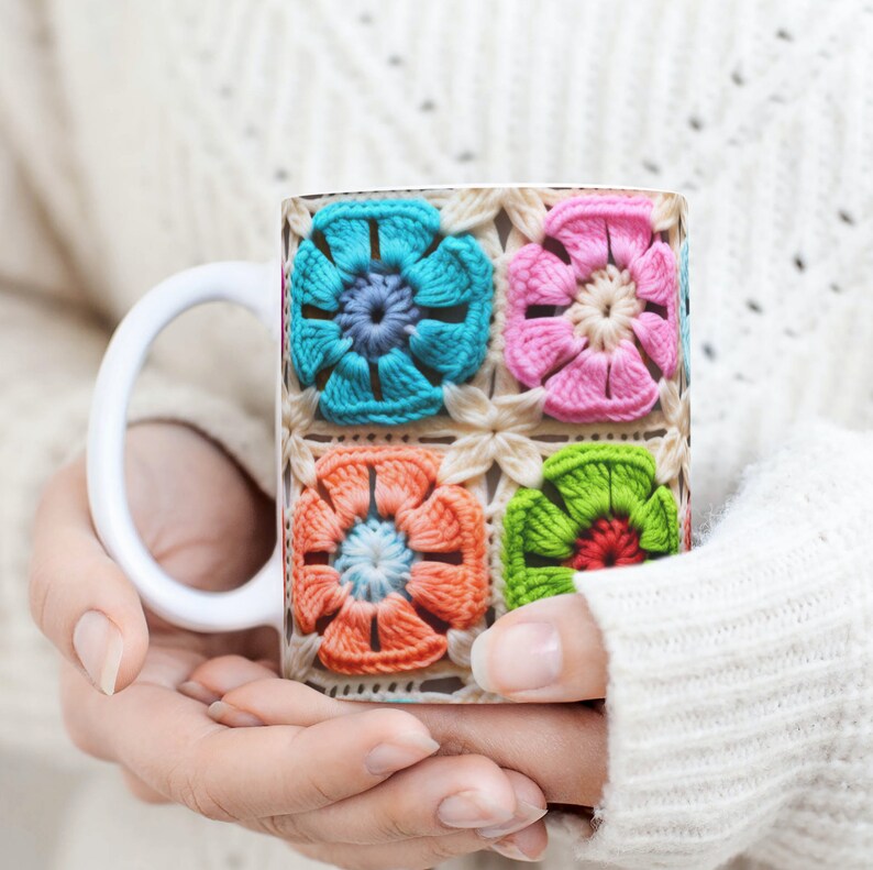 Puede incluir: Taza de cer&aacute;mica blanca con un dise&ntilde;o de ganchillo colorido con flores rosas, azules, verdes y naranjas.