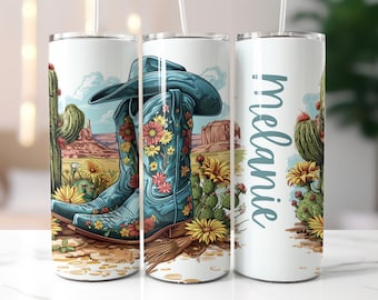 Könnte beinhalten: Ein weißer Becher mit einem blauen und floralen Design von Cowboystiefeln und Kakteen. Der Becher trägt den Namen "Melanie".