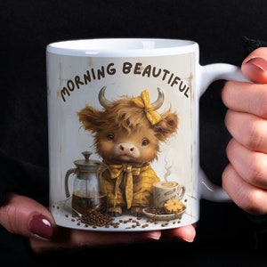 May include: White ceramic mug with a brown and yellow illustration of a Highland cow wearing a yellow and white polka dot shirt and a yellow bow. The mug has the text "Morning Beautiful" printed on it.