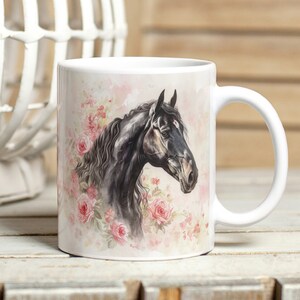 May include: White ceramic mug with a watercolour illustration of a black horse's head and pink roses. The horse has a detailed mane and a calm expression. The background is a soft, pastel pink.