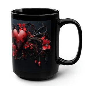 May include: Black coffee mug with a red heart and floral design. The heart is surrounded by red flowers and black vines.