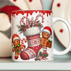 May include: White ceramic mug with a Christmas design. The mug features a red and white stocking filled with candy canes, a gingerbread person holding a gift, and another gingerbread person wearing a red hat. The mug has a white handle.