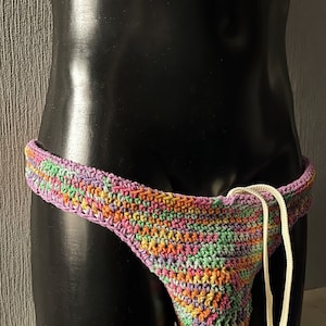 May include: Multicoloured crochet underwear with a white drawstring. The underwear is made with a variety of colours, including pink, green, orange, and yellow.