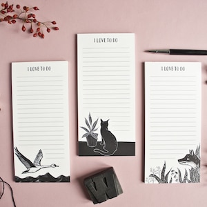May include: Three black and white to-do list notepads with illustrations of a goose, a cat, and a fox. Each notepad has the text "I love to do" at the top.