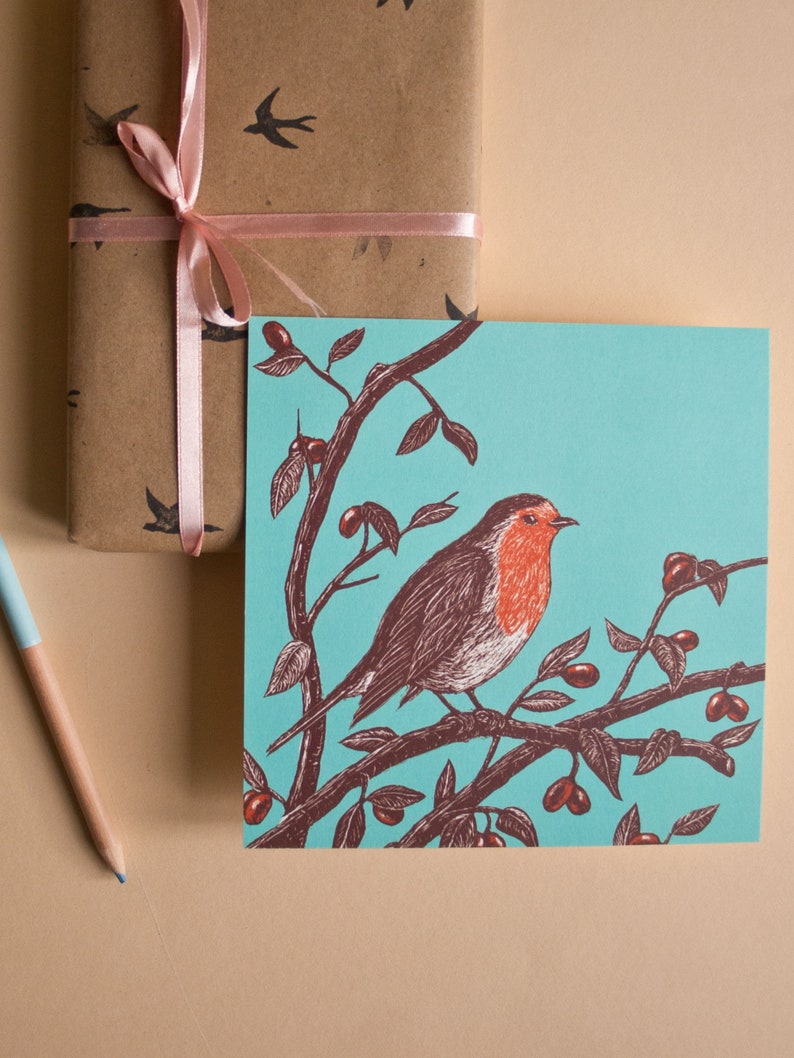 May include: A robin perched on a branch with red berries, against a turquoise background. The robin has a red breast and brown wings. The illustration is in a vintage style.